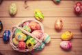 Colorful hand painted Easter eggs in basket and on wood. Handmade vintage decoration Royalty Free Stock Photo