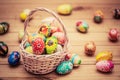 Colorful hand painted Easter eggs in basket and on wood. Handmade vintage decoration Royalty Free Stock Photo