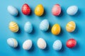 Colorful handcrafted Easter eggs on blue backdrop. Minimalistic concept. Copy space image