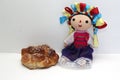 Colorful handmade cloth doll with pan de muerto from the town with sesame in the offering for the Day of the All Souls and All Sai