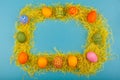 Colorful handmade Easter eggs in a frame made of dry grass. The view from the top. Isolated on a blue background Royalty Free Stock Photo