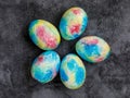 Colorful handmade Easter eggs painted like Earth on black marble background. Minimal happy Easter holiday conceprt. Top