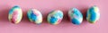 Colorful handmade Easter eggs painted like Earth on pink paper background. Minimal happy Easter holiday conceprt. Top
