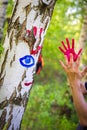 Colorful handprints on a birch tree