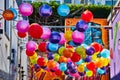 Colorful hanging balloon balls at Ghirardelli Square with mural art on nearby walls