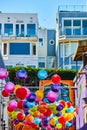 Colorful hanging balloon balls with mural art and nearby apartments on hill