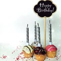 Colorful happy birthday cupcakes with candles with compliments. Birthday cupcake and black board with chalk inscription Royalty Free Stock Photo