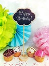 Colorful happy birthday cupcakes with candles with compliments. Birthday cupcake and black board with chalk inscription Royalty Free Stock Photo