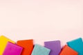 Colorful hardcover books on pastel pink background. Education, self-learning, book swap, bookcrossing concept. Top view