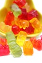 Colorful haribo bear candies pouring out of yellow bowl