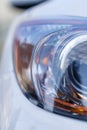 Colorful headlights of white car after the rain at night on car parking Royalty Free Stock Photo