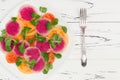 Colorful and healthy carpaccio salad with watermelon radish, tomato and corn salad. Top view, free text copy space
