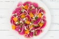 Colorful and healthy watermelon radish, orange and goat cheese carpaccio salad. Top view, free text copy space