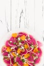 Colorful and healthy watermelon radish, orange and goat cheese carpaccio salad. Top view, free text copy space