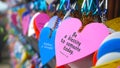 Colorful hearts hanging together on wall on the street with random text messages - Be a blessing to someone today. Proverbs 11.25