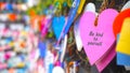 Colorful hearts on the street hanging on wall with text message - Be kind to yourself. Self love and care concept.