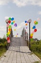 Colorful helium baloons at bridge opposite blue sky Royalty Free Stock Photo