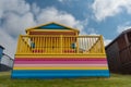 Colorful holiday beach hut holiday homes against blue cloudy sky