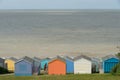 Colorful holiday beach huts homes facing the calm blue sea.