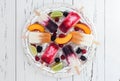 Colorful homemade popsicles with fresh fruits and berries on ice cubes in vintage silver tray.