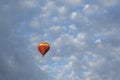 Colorful Hot Air Balloon in flight against a deep blue sky and clouds. Royalty Free Stock Photo