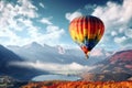 Colorful hot air balloon floating in the clear sky above the lake and mountains Royalty Free Stock Photo