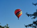Colorful hot air balloon flying through the blue sky Royalty Free Stock Photo