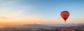 Colorful hot air balloon flying early in the morning over the mountain. Scenic sunrise or sunset view Royalty Free Stock Photo