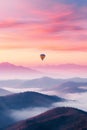 Colorful hot air balloon flying early in the morning over the mountain. Scenic sunrise or sunset view Royalty Free Stock Photo