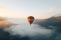 Colorful hot air balloon flying early in the morning over the mountain. Scenic sunrise or sunset view Royalty Free Stock Photo