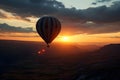 Colorful hot air balloon flying early in the morning over the mountain. Scenic sunrise or sunset view Royalty Free Stock Photo