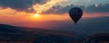 Colorful hot air balloon flying early in the morning over the mountain. Scenic sunrise or sunset view Royalty Free Stock Photo