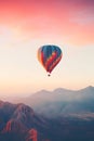 Colorful hot air balloon flying early in the morning over the mountain. Scenic sunrise or sunset view Royalty Free Stock Photo