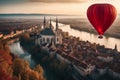 colorful hot air balloon flying over a medieval city with towers and churches at sunset - Royalty Free Stock Photo