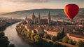 colorful hot air balloon flying over a medieval city with towers and churches at sunset - Royalty Free Stock Photo