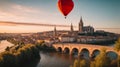 colorful hot air balloon flying over a medieval city with towers and churches at sunset - Royalty Free Stock Photo