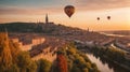 colorful hot air balloon flying over a medieval city with towers and churches at sunset - Royalty Free Stock Photo