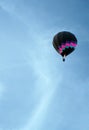 A colorful hot air balloon rises into an azure sky Royalty Free Stock Photo