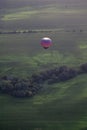 A colorful hot air balloons flies above the Iowa countryside.