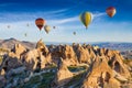 Colorful hot air balloons fly in blue sky over amazing rocky valley in Cappadocia, Turkey Royalty Free Stock Photo