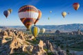 Colorful hot air balloons fly in blue sky over amazing rocky valley in Cappadocia, Turkey Royalty Free Stock Photo