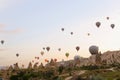 Colorful hot air balloons flying over Cappadocia rocks in Turkey.