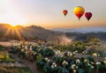 Colorful hot-air balloons flying over the mountain at sunset. Hot air balloon floating over the hill in sunrise. Travel and air Royalty Free Stock Photo