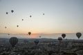 Colorful hot air balloons flying over rock and valley landscape in morning fog at sunrise in Cappadocia, Turkey Royalty Free Stock Photo