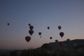 Colorful hot air balloons flying over rocky landscape at sunset sky Royalty Free Stock Photo