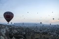 Colorful hot air balloons flying over the valley and rock formations with chimneys near Goreme, Cappadocia, Turkey Royalty Free Stock Photo