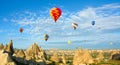 Colorful hot air balloons flying over volcanic cliffs at Cappadocia, Anatolia, Turkey. Panorama Royalty Free Stock Photo