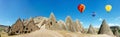 Colorful hot air balloons flying over volcanic cliffs at Cappadocia, Anatolia, Turkey