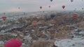 Colorful Hot Air Balloons over the snowy fairy chimneys at sunrise in Cappadocia