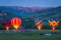 Colorful hot air balloons soar above stunning mountain peaks in picturesque landscape